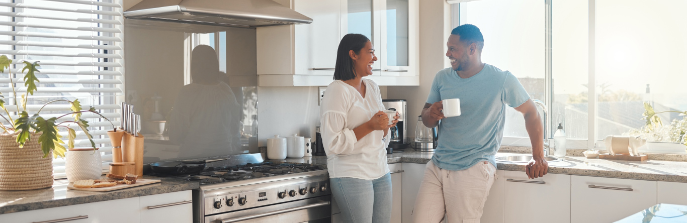 Couple in kitchen drinking coffee